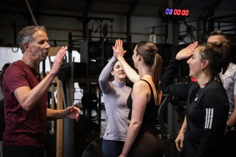 Groep geeft elkaar high fives na afloop van de HIIT-training