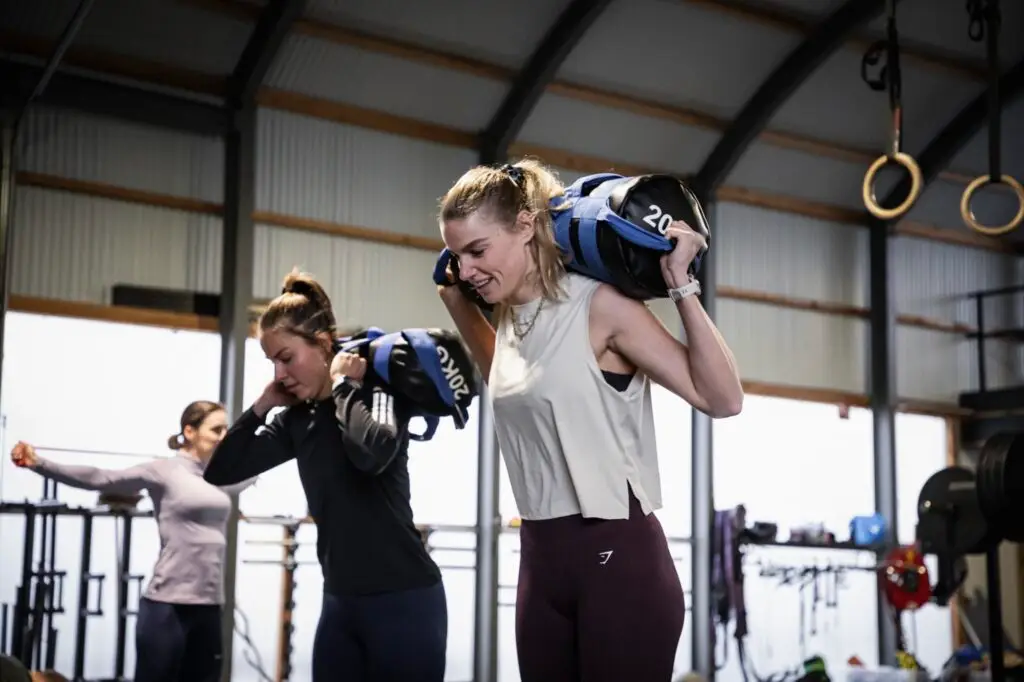 Twee leden dragen een sandbag van 20 kilo op de schouder tijdens de HYWOD