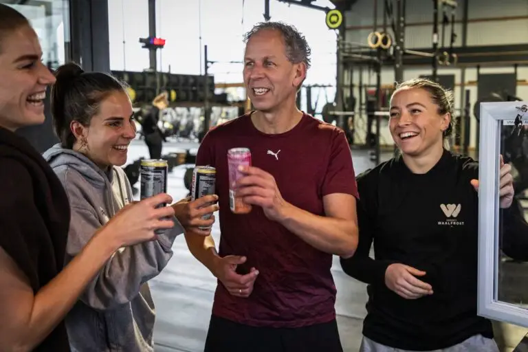 Lachende leden en een trainer maken kennis na de training
