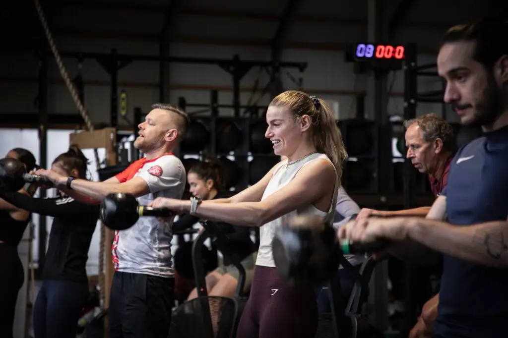 Groep leden maakt kettlebell swings naast elkaar tijdens de KettlebellWOD