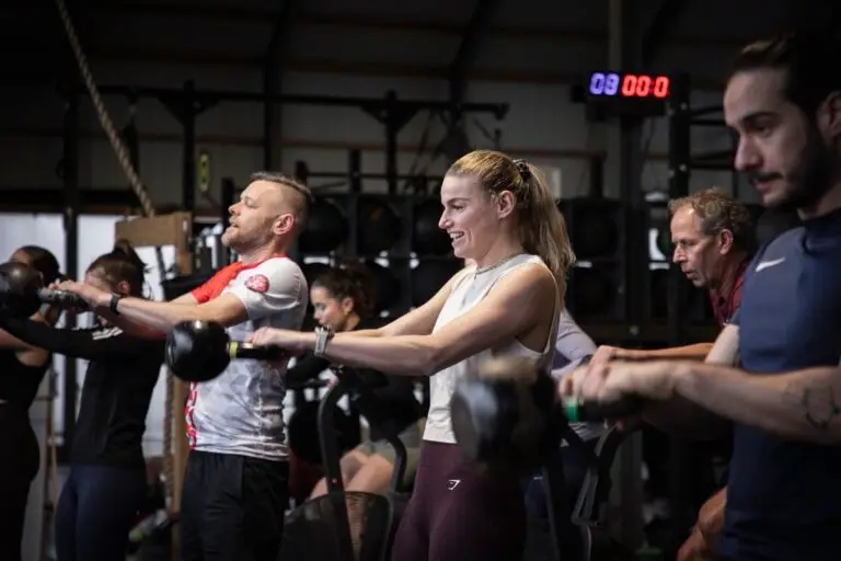 Groep leden maakt kettlebell swings naast elkaar tijdens de KettlebellWOD