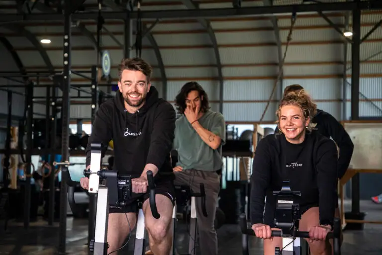 Lachende leden op de bike ergs tijdens een METCON