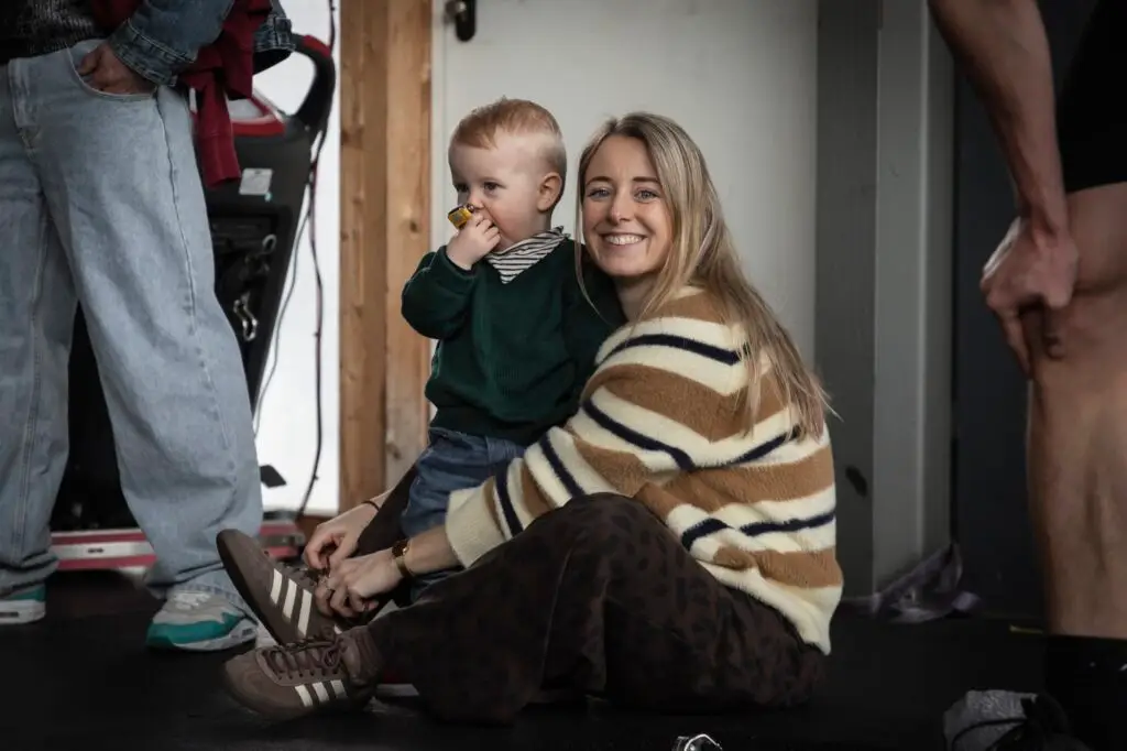 Lachende moeder met haar kindje op schoot in de box van CrossFit Waalfront