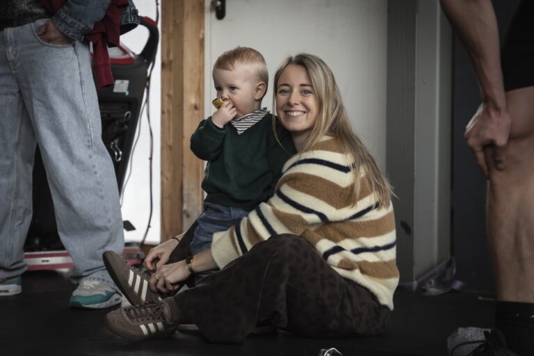 Lachende moeder met haar kindje op schoot in de box van CrossFit Waalfront