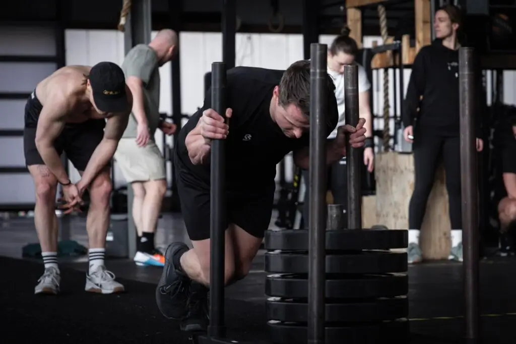 Lid duwt een zwaarbeladen sled tijdens StrongFit