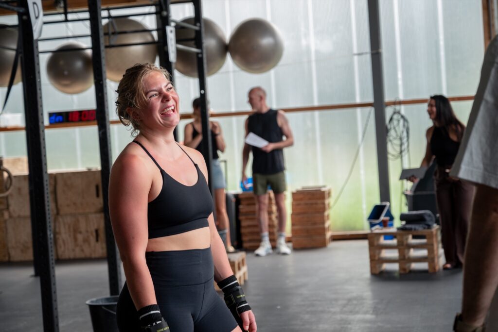 Lachend lid met polsbandages tijdens de Strong(wo)man-training