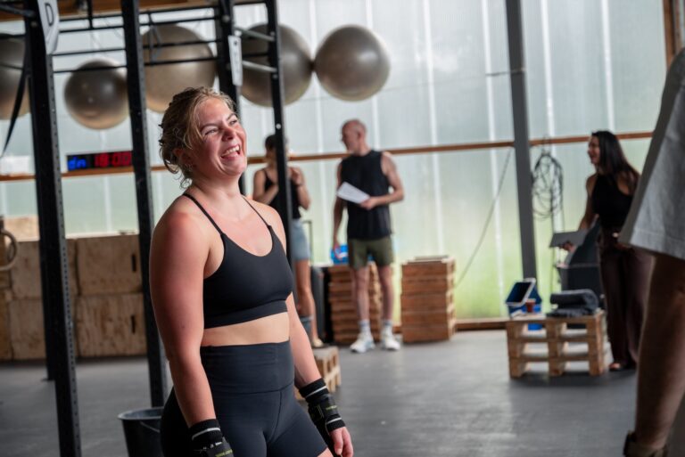 Lachend lid met polsbandages tijdens de Strong(wo)man-training